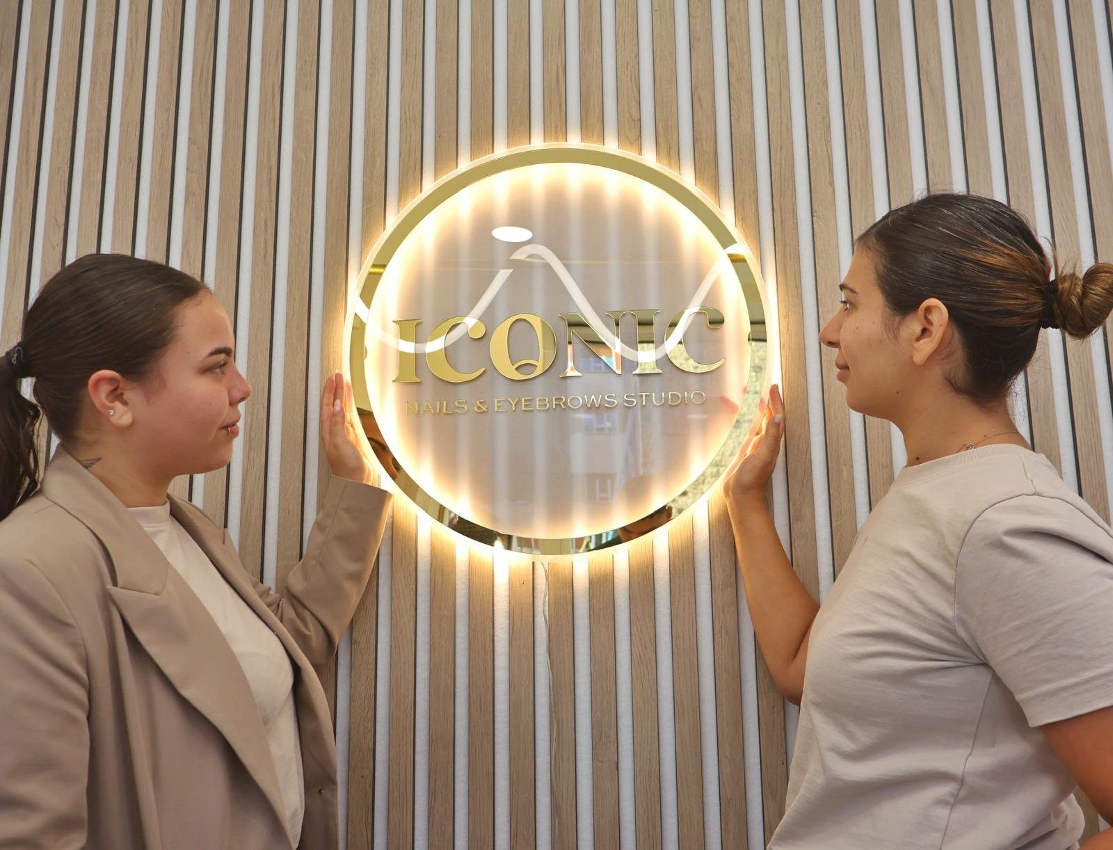 Paula y Antonella, el equipo de ICONIC Studio, junto al rótulo del estudio en Oviedo